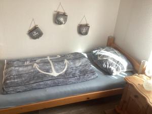 a bed in a room with hangers on the wall at Ferienhaus Ankerplatz in Bedekaspel +5 photos