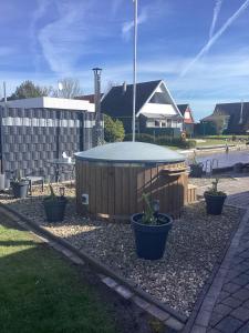 a circular pool in a yard with a table at Ferienhaus Ankerplatz in Bedekaspel