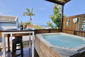 a hot tub on a deck with a table and a bar at Breakers View in Sheffield Beach
