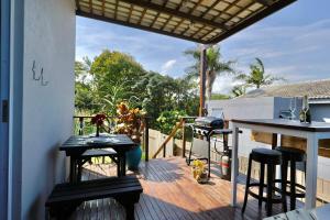 a patio with a table and chairs on a deck at Breakers View in Sheffield Beach +34 photos
