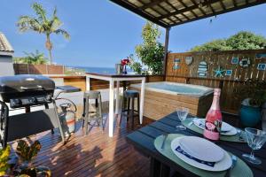 a patio with a hot tub and a table with a grill at Breakers View in Sheffield Beach