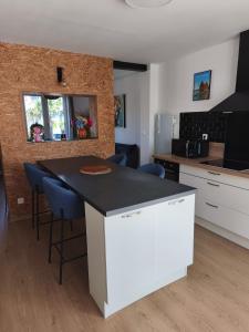 a kitchen with a white island in a room at La maison du 116 in Gravelines