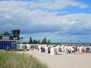 a beach with a bunch of white chairs on the sand at Fh "luv" in Ueckermünde