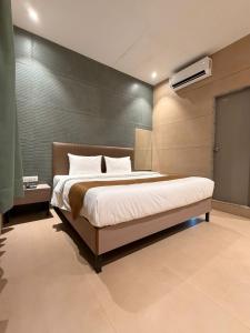 a bedroom with a large bed in a room at Shelter Suites - Formerly known as Fisco The Hub Link in Mumbai +27 photos