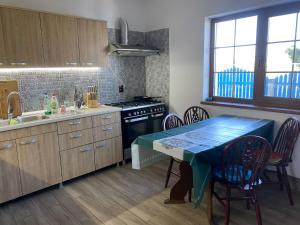 a kitchen with a table with chairs and a stove at Casa cu flori in Tulcea