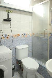 a bathroom with a toilet and a shower and a sink at apartament dato in Batumi