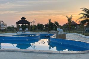 a swimming pool with a fountain and a gazebo at Yadus By Alcor in Bīsalpur