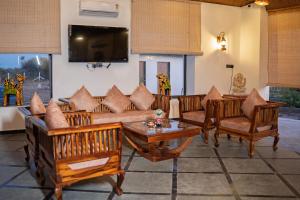 a living room with wooden furniture and a flat screen tv at Yadus By Alcor in Bīsalpur