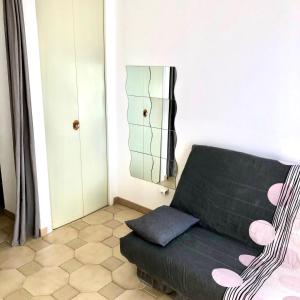 a living room with a green couch and a mirror at résidence Fogata in LʼÎle-Rousse