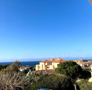 a house on a hill with the ocean in the background at résidence Fogata in LʼÎle-Rousse