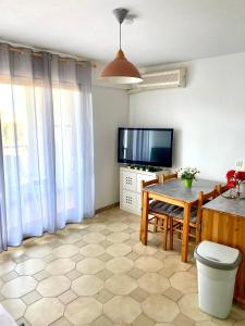 a living room with a table and a television at résidence Fogata in LʼÎle-Rousse