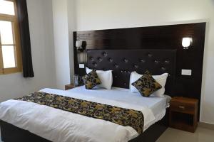 a bedroom with a large bed with a black headboard at The Apricot Palace in Kargil