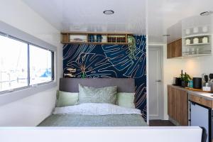 a small bedroom with a bed in a tiny house at Tiny Olav houseboat close to the beach and restaurants by Weltevreden Experience in Zeewolde