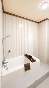 a bathroom with a white tub and a sink at Kangen Boutique Hotel in Yogyakarta