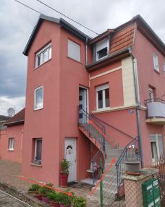 a red house with a staircase in front of it at séjour en Alsace in Ingersheim