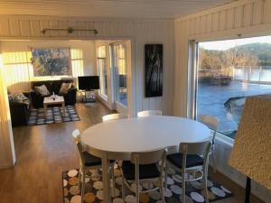 a living room with a white table and chairs at Havblikk, cozy cabin by the sea with beautiful views in Mandal