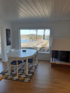a dining room with a table and a view of a beach at Havblikk, cozy cabin by the sea with beautiful views in Mandal +22 photos