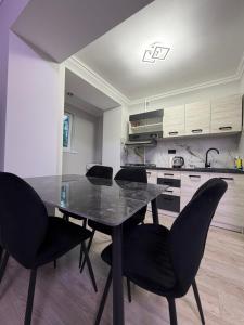 a dining room table with black chairs in a kitchen at Apartament Rîșcani in Chişinău