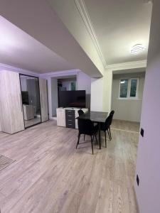 a dining room with a table and chairs in a room at Apartament Rîșcani in Chişinău
