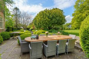 a wooden table and chairs in a garden at West Kennett House in Marlborough