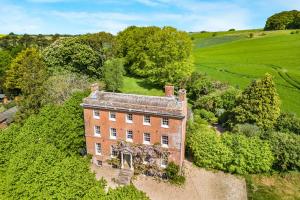 an aerial view of an old brick house in a field at West Kennett House in Marlborough