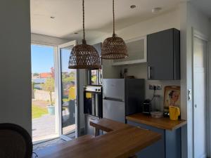 a kitchen with two pendant lights and a table at Maison semi individuelle avec jardin in Ambleteuse