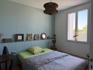 a bedroom with a bed and a window at Maison semi individuelle avec jardin in Ambleteuse