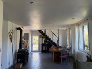 a living room with a staircase and a table and chairs at Maison semi individuelle avec jardin in Ambleteuse +11 photos