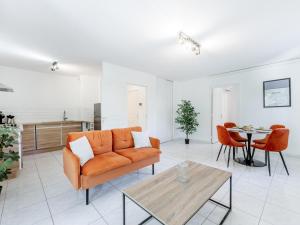 a living room with an orange couch and a table at Le PTIT VENT, cosy et bien situé in Cavalaire-sur-Mer