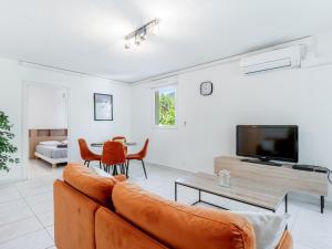 a living room with a couch and a tv at Le PTIT VENT, cosy et bien situé in Cavalaire-sur-Mer +2 photos