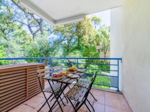 a balcony with a table and chairs on a balcony at Le PTIT VENT, cosy et bien situé in Cavalaire-sur-Mer