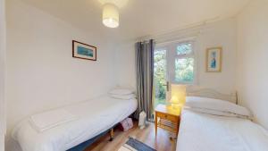 two beds in a room with a window at 87 Strawberry Hill, Tolroy Manor in Hayle +16 photos