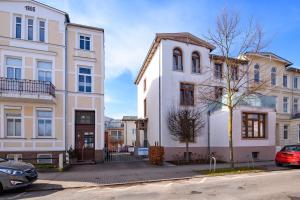a group of buildings on a street with cars parked at Haus Seewind Warnemünde in Rostock