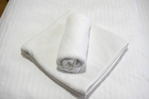 a roll of white towels sitting on a bed at Apartmani Narona in Jablanica +80 photos