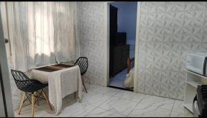 a room with a table and two chairs and a mirror at Kit net familiar in Vitória