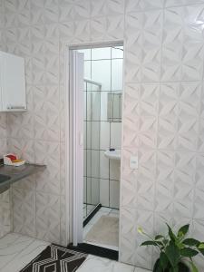 a shower with a glass door in a bathroom at Kit net familiar in Vitória