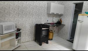 a small kitchen with a sink and a microwave at Kit net familiar in Vitória