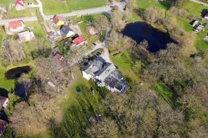 an aerial view of a house with trees and a lake at Gutshaus Bartelshagen in Bartelshagen +45 photos