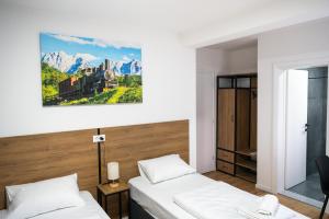 a bedroom with two beds and a painting on the wall at Apartmani Narona in Jablanica