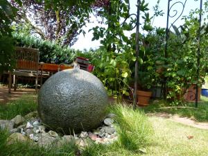 a large rock sitting in the middle of a garden at Eisvogel- Ferienwohnung in Marienfelde