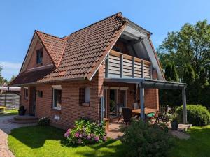 a brick house with an umbrella in the yard at Ferienhaus Hieve in Marienwehr
