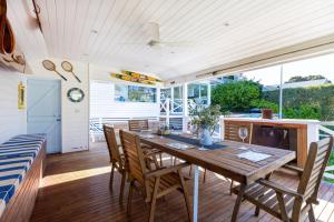 a kitchen and dining room with a wooden table and chairs at Parkview Cottage Portsea in Portsea
