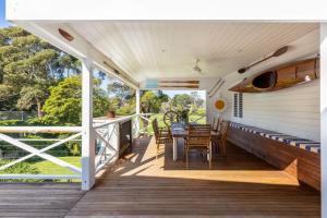 a deck with a table and chairs on it at Parkview Cottage Portsea in Portsea