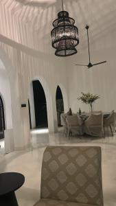 a living room with a chandelier and a table and chairs at Casa Dega in Balapitiya