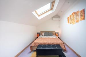 a attic bedroom with a bed and a skylight at Grand Loft avec Billard Netflix et Climatisation in Socourt