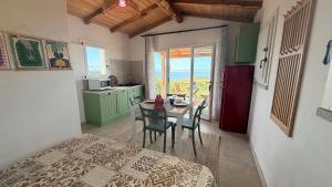 a room with a bed and a table with chairs at Isola Rossa Appartamenti vista mare in collina in Isola Rossa