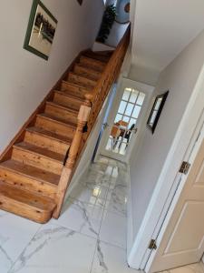 a staircase in a home with marble flooring and wooden steps at Townhouse Sleeps 8 - Garden Wifi Free Parking in Belmullet