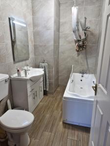 a bathroom with a white sink and a toilet at Townhouse Sleeps 8 - Garden Wifi Free Parking in Belmullet +68 photos