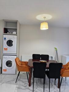 a dining room with a table and chairs and a washing machine at Townhouse Sleeps 8 - Garden Wifi Free Parking in Belmullet