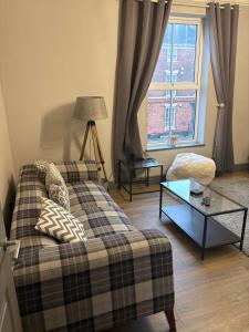 a living room with a couch and a window at Impressive City Centre Apartment in Derby